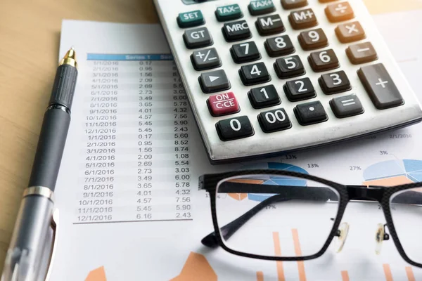 A pénzügyi táblázatok az asztalon laptop, számológép, toll és g — Stock Fotó