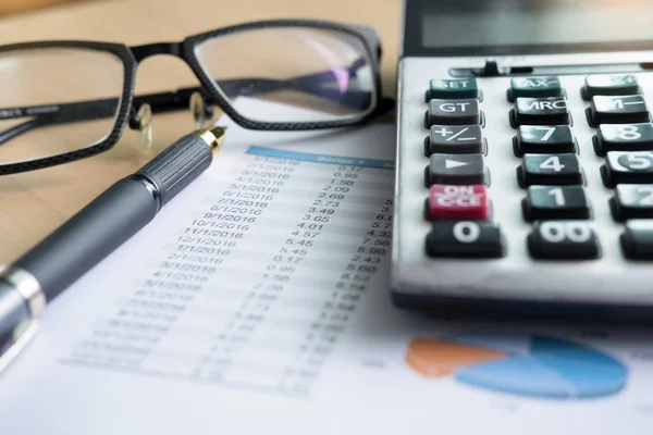 Gráficos financieros sobre la mesa con calculadora —  Fotos de Stock