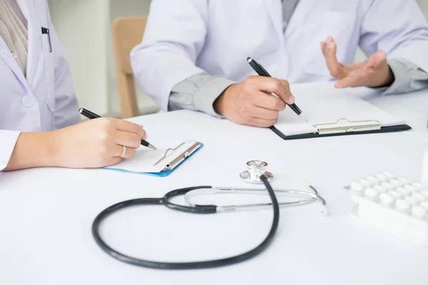 Dos doctores discutiendo notas de pacientes — Foto de Stock