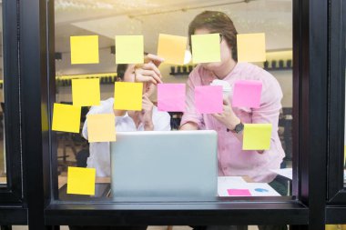 Yapışkan notlar ofis cam duvara yapışmasını iş adamı ve