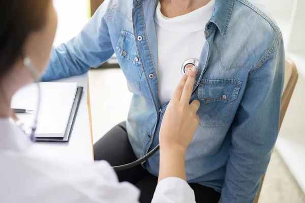 Doktor stetoskop ile neşeli genç hastalarda göğüs için dinleme — Stok fotoğraf