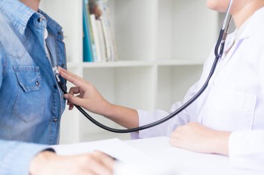 Doktor stetoskop ile neşeli genç hastalarda göğüs için dinleme