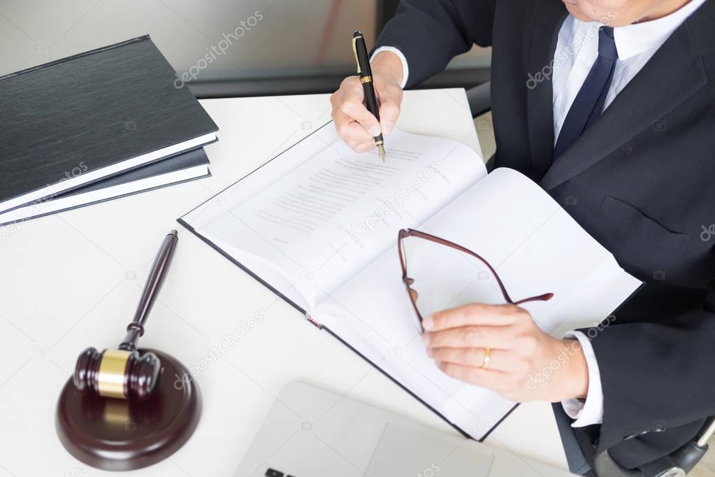 lawyer hand writes the document in court (justice, law) with sou