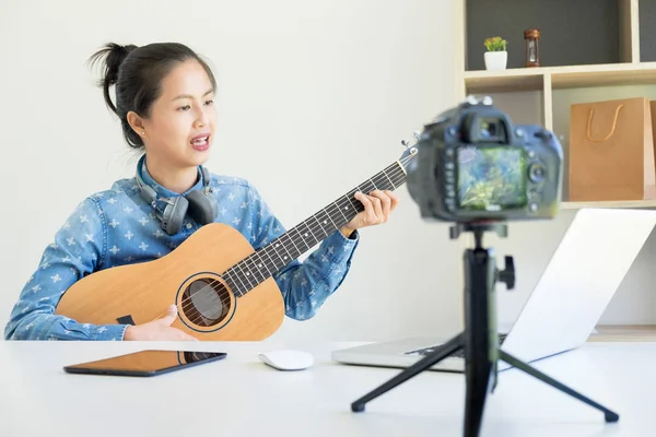 Kvinnor sjunger en låt med gitarr i händerna Använd kamera att sända l — Stockfoto