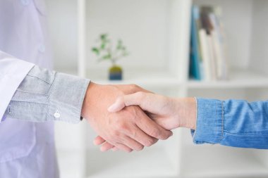 Doktor eller tıbbi ofiste glas giyen hastayla sallıyor