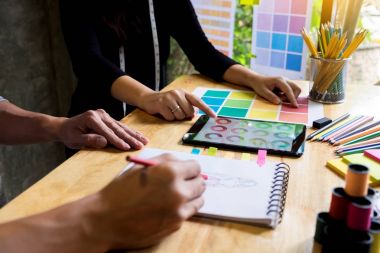 sketche çizim ve moda tasarımcıları çalışan iki genç kadın