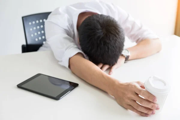 疲れたビジネスマンは寝ている彼のテーブルでノート パソコン. — ストック写真