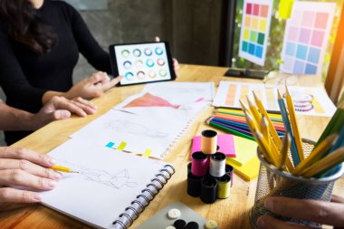 sketche çizim ve moda tasarımcıları çalışan iki genç kadın