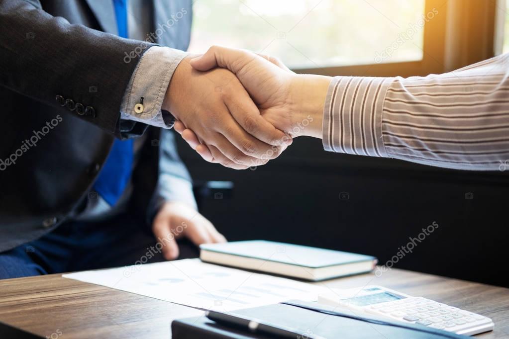 Two confident business man shaking hands during a meeting in the