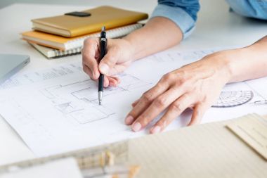 Kişinin mühendis el çizim planı üzerinde mavi baskı veya çalışma pro