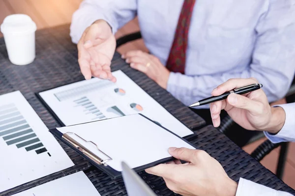 Mensen uit het bedrijfsleven discussiëren samen over er werken door grafiek docum — Stockfoto