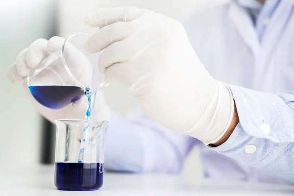 Cientistas e equipamentos científicos verter reagentes de mistura liqi — Fotografia de Stock