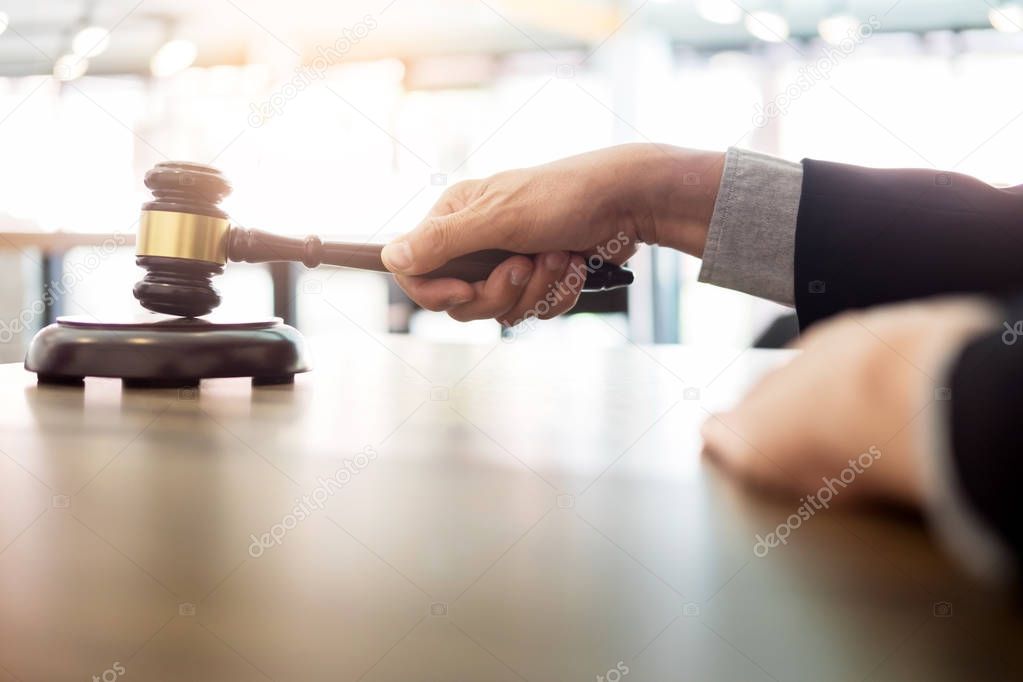Male Judge lawyer In A Courtroom Striking The Gavel on sounding 