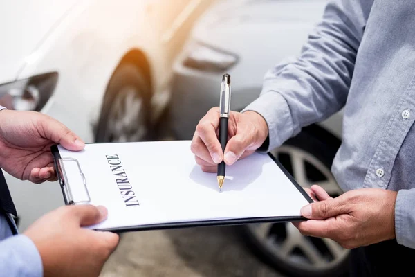汽车保险代理发送一支钢笔给他的顾客签名保险法 — 图库照片