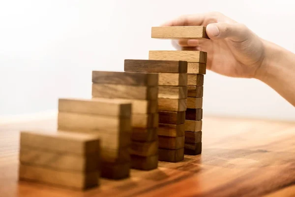 Zakelijke man hand zetten houtblokken schikken stapelen voor devel — Stockfoto