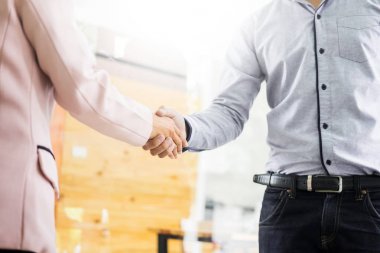 Bir toplantı sırasında el sıkışan iki emin iş adamı