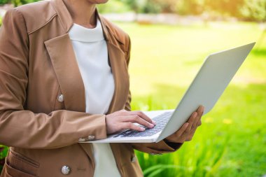 Bahçe masada dizüstü kullanarak iş kadını ele.