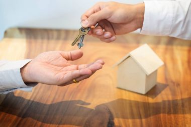 Emlakçı bir ofis masasında oturan takım elbiseli h teslim