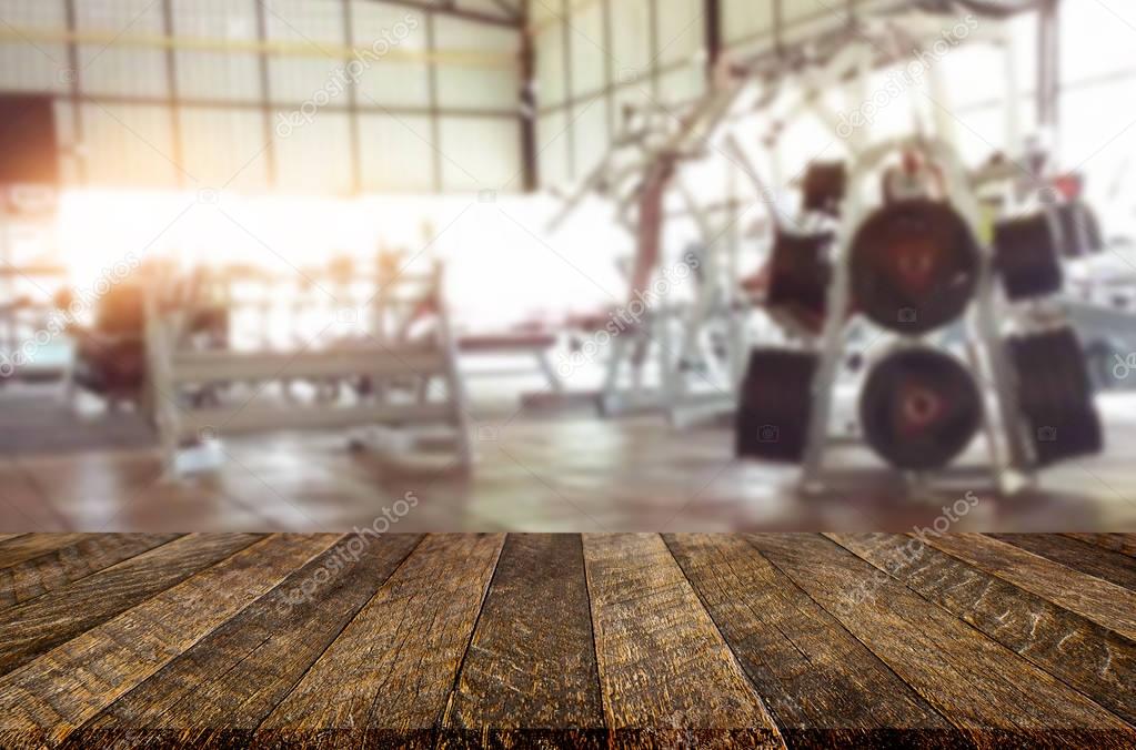 Wooden table on blurred background of fitness gym interior of mo