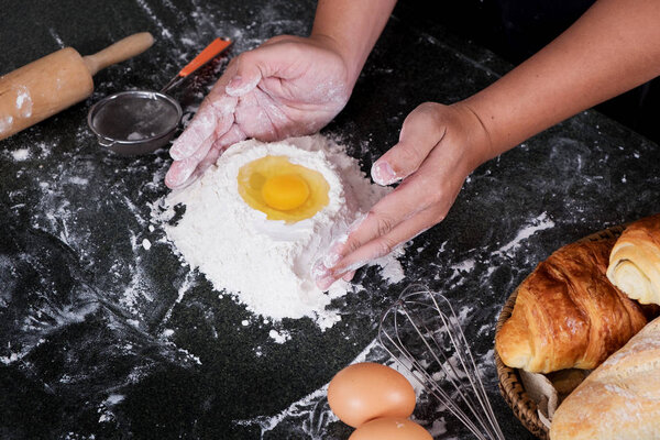 Woman's hands knead dough with flour, eggs and ingredients. at k