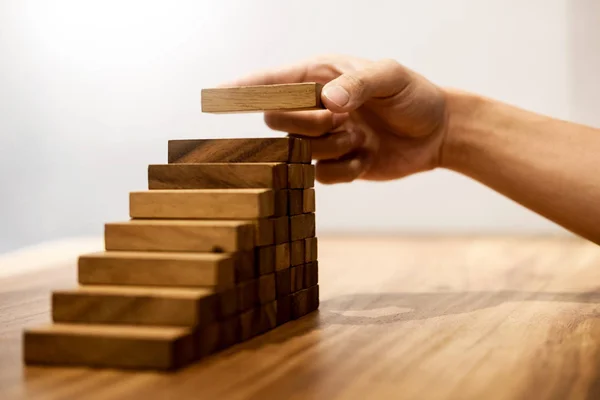 Zakelijke man hand zetten houtblokken schikken stapelen voor devel — Stockfoto