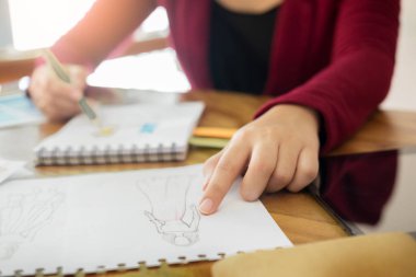 Moda Tasarımcısı skeçler clo için çizim olarak çalışan genç kadınlar