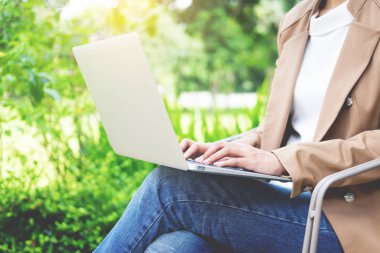 Bahçe masada dizüstü kullanarak iş kadını ele.