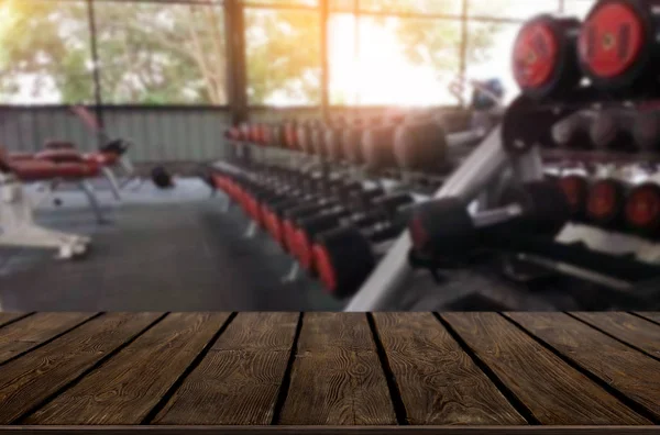 Drewniany stół na tło zamazane pole fitness siłownia wnętrza mo — Zdjęcie stockowe
