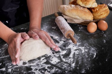 Kadının elleri ile un, yumurta ve malzemeler hamur yoğurmak. k