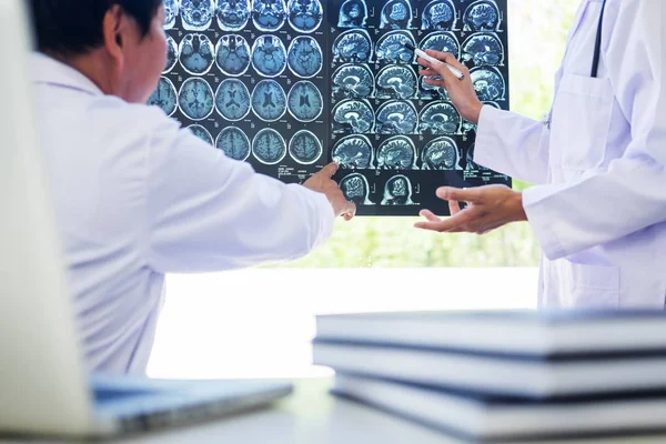 Two doctors analyzing a scan or x-ray film or  explains a CT sca — Stock Photo, Image