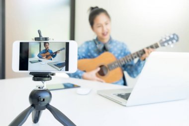kadın el kullanma fotoğraf makinesi l yayınlamak için içinde gitar ile bir şarkı söyle