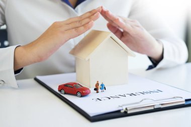 bir ev, bir araba ve bir aile koruma insanlar kavramı üzerinde elleriyle sigorta 