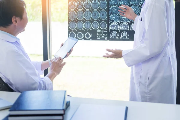 Dos doctores analizando una tomografía o radiografía o explicando una TC sca — Foto de Stock