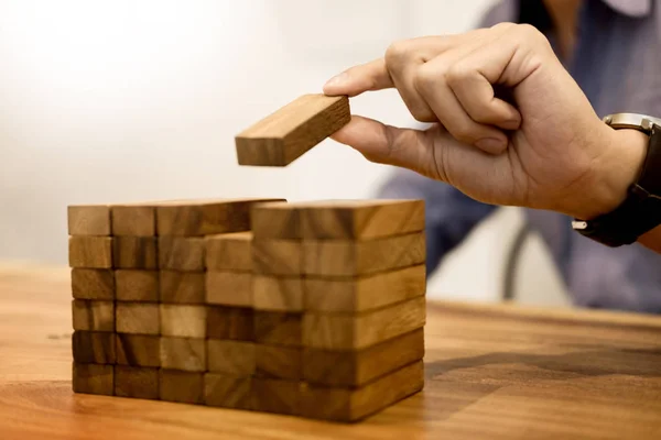 Mão de engenheiro jogando um jogo de blocos de torre de madeira no blueprint o — Fotografia de Stock