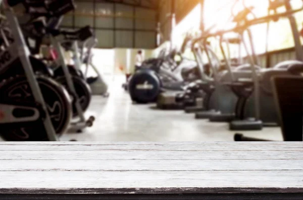 Tavolo in legno su sfondo sfocato di palestra fitness interno di mo — Foto Stock