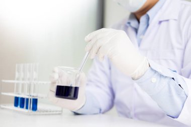 bilim adamı reaktifler kabı bilim laboratuarında kıpırdanırken.