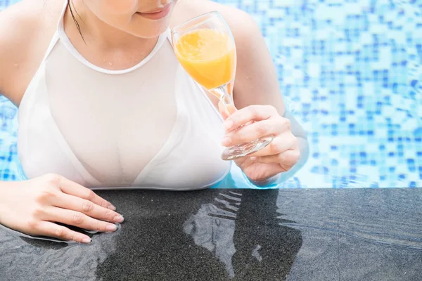 Hermosa chica bebiendo cóctel cosmopolita, mintiendo po natación — Foto de Stock