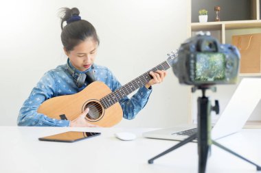 kadın el kullanma fotoğraf makinesi l yayınlamak için içinde gitar ile bir şarkı söyle