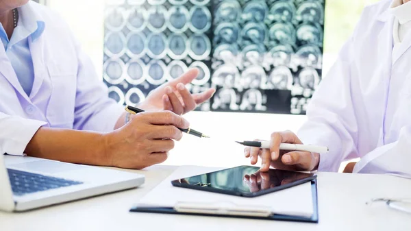 Dos doctores analizando una tomografía o radiografía o explicando una TC sca — Foto de Stock