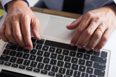 Dizüstü bilgisayar, tablet ve grafik dat ile ofisinde çalışan iş adamı