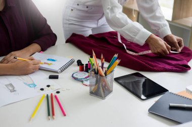 sketche çizim ve moda tasarımcıları çalışan iki genç kadın