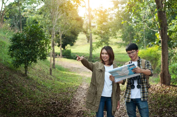 Par av turister på väg till skogen med kartor i hand Sök — Stockfoto