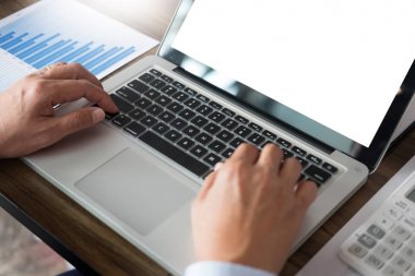Dizüstü bilgisayar, tablet ve grafik dat ile ofisinde çalışan iş adamı