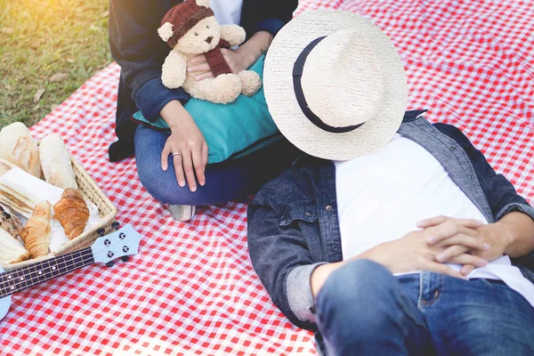Випадковий красивий чоловік поклав голову на коліна своїй дружині під час пікніка — стокове фото