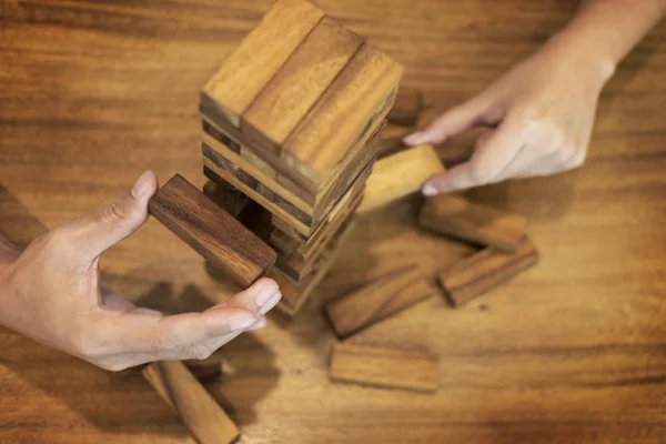 Hombre de negocios colocación de bloques de madera en un concepto de torre de riesgo con —  Fotos de Stock