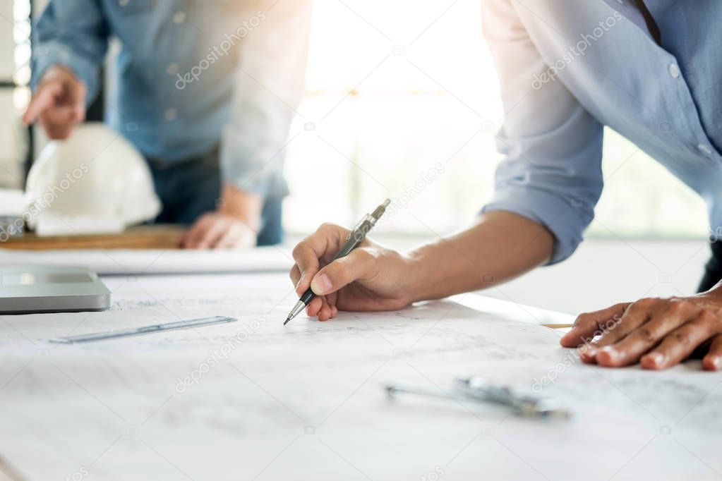 Close-up Of Person's engineer Hand Drawing Plan On Blue Print wi