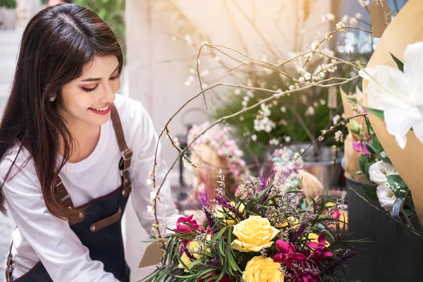 young women business owner florist making bouquet  in front of f