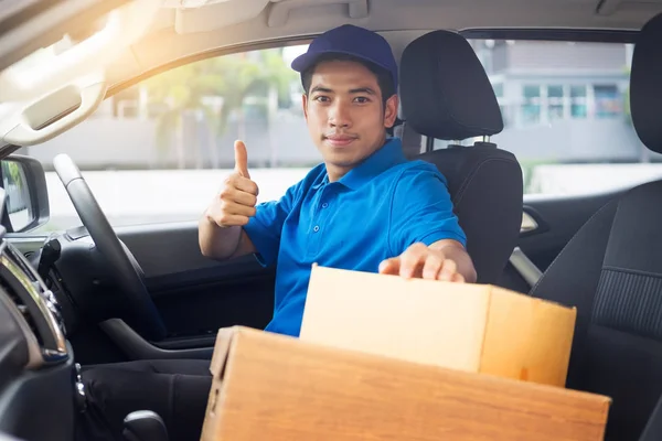 Levering messenger man met kartonnen doos buiten het magazijn — Stockfoto