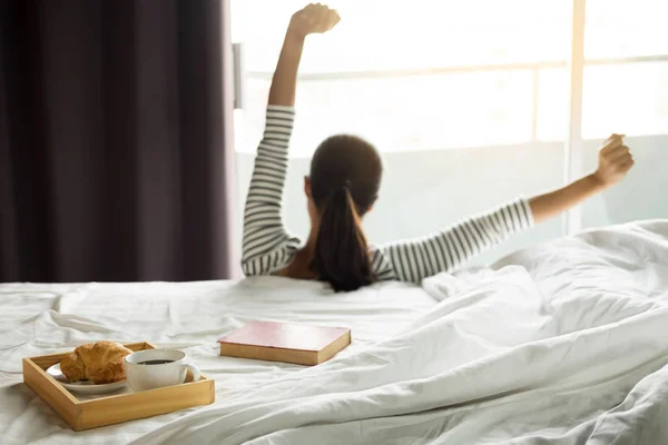 Atractivo asiático mujer estirarse uno mismo despertar en la cama habitación . —  Fotos de Stock