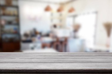 Seçilmiş odak noktası boş kahverengi ahşap masa ve kafeterya veya restoranın arka planı bokeh görüntülü bulanık. Fotomontaj ya da ürün gösterimi için